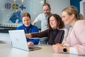 A group of people looking at a computer.